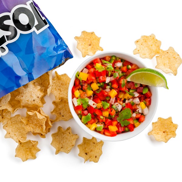 Scoop tortilla chips served with a side of summertime salsa, garnished with a lime wedge