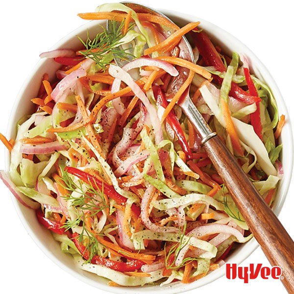 Bowl filled with sliced vegetables and a spoon on top