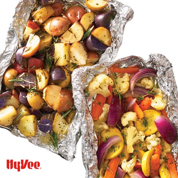 Multi colored potatoes, summer squash, red onion, cauliflower, and carrots in a tin foil package