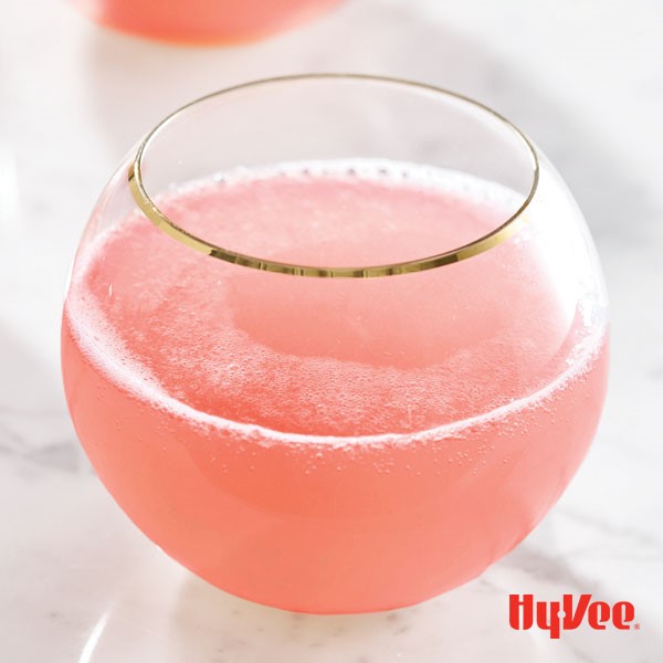 Pink mocktail in a glass with a golden rim