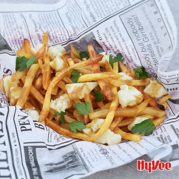 Fries topped with Hatch pepper cheese curds, gravy, and chopped parsley leaves