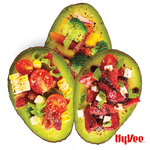 Avocado halves filled with fresh vegetables and fruits