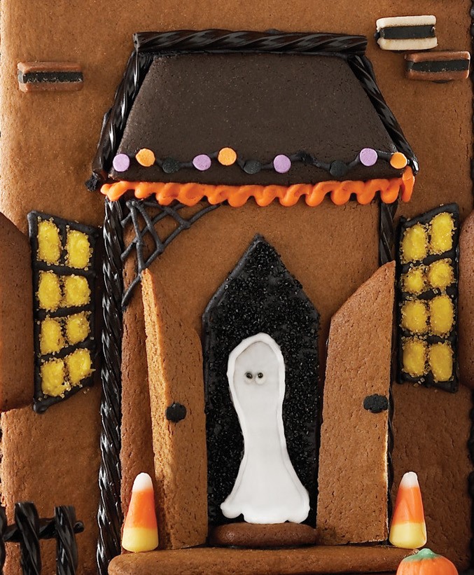 Front of Gingerbread Halloween House Decorated with Frosting and a White Ghost in Front Door