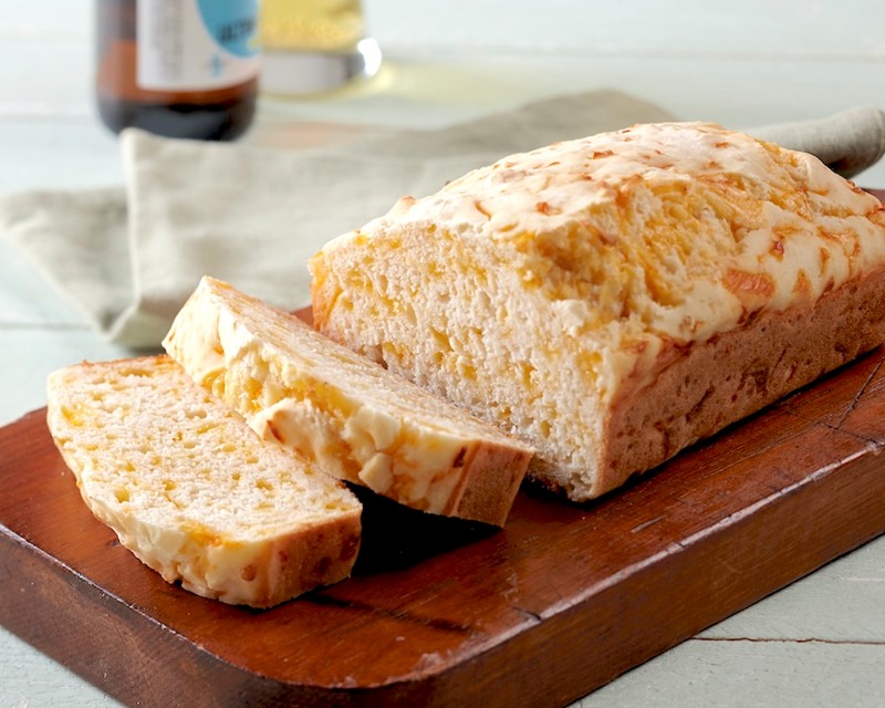 Gluten-Free Cheddar Garlic Beer Bread Sliced on Wooden Cutting Board