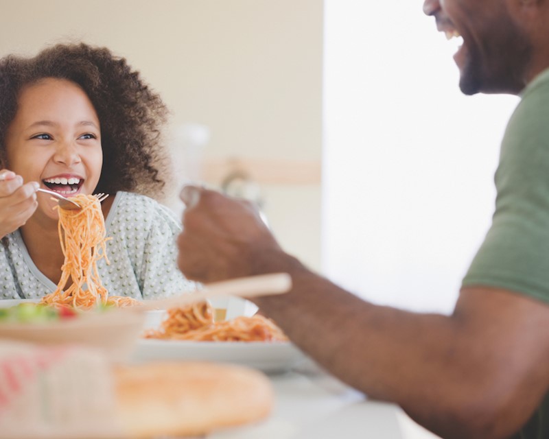 Girl Eating Pasta with Dad in the Kitchen