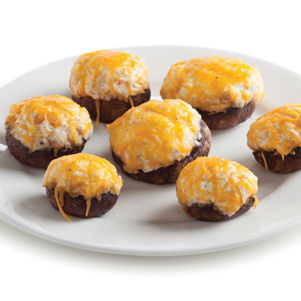 a plate of stuffed mushroom caps smothered in cheese