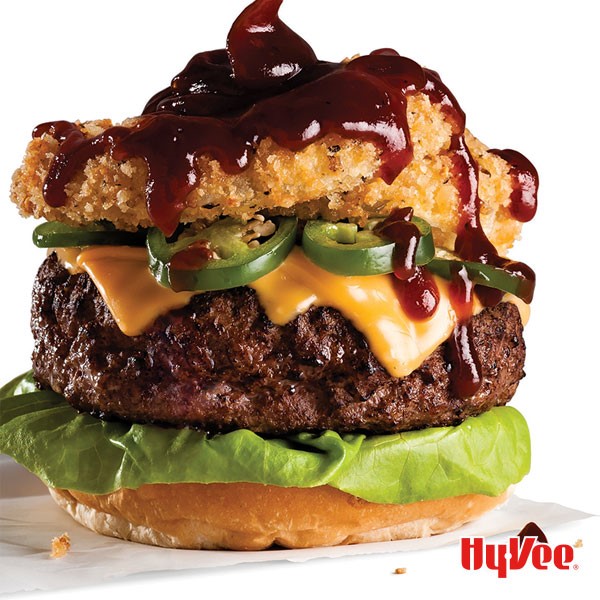 Rodeo Burger with Melted Yellow Cheese, Jalapeno Slices, Onion Rings, and Barbecue Sauce