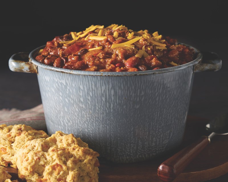 Pot of Chili with Yellow Shredded Cheese and Biscuits on the Side