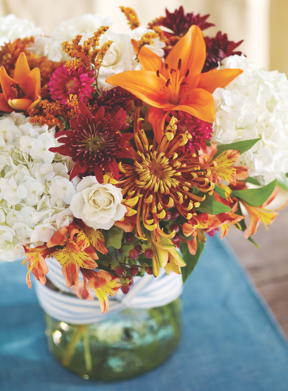 Arrangement of lillies, tiger lillies, hydrangeas, and red and orange mums