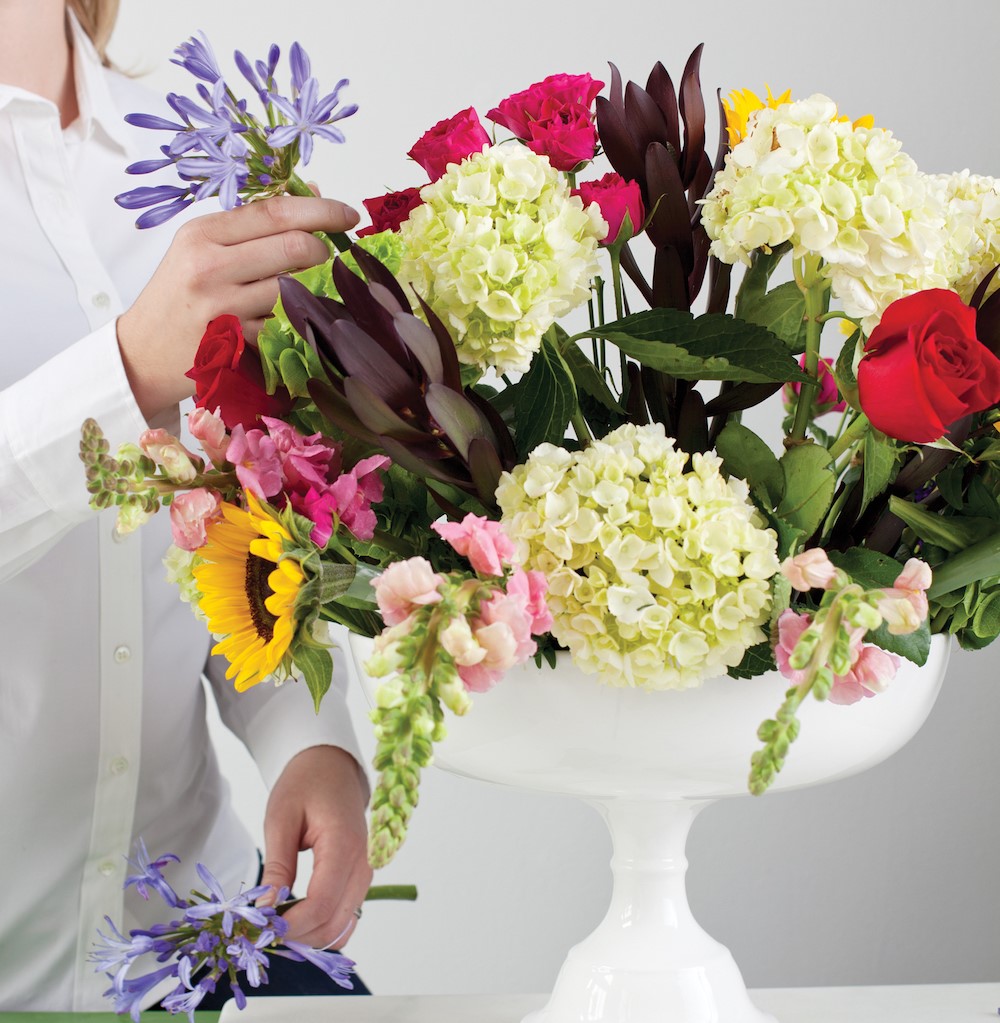 placing flowers in the arrangement