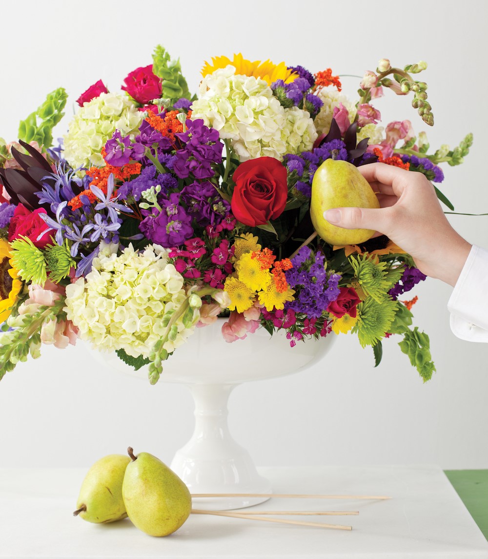 placing a skewered pear into the bouquet