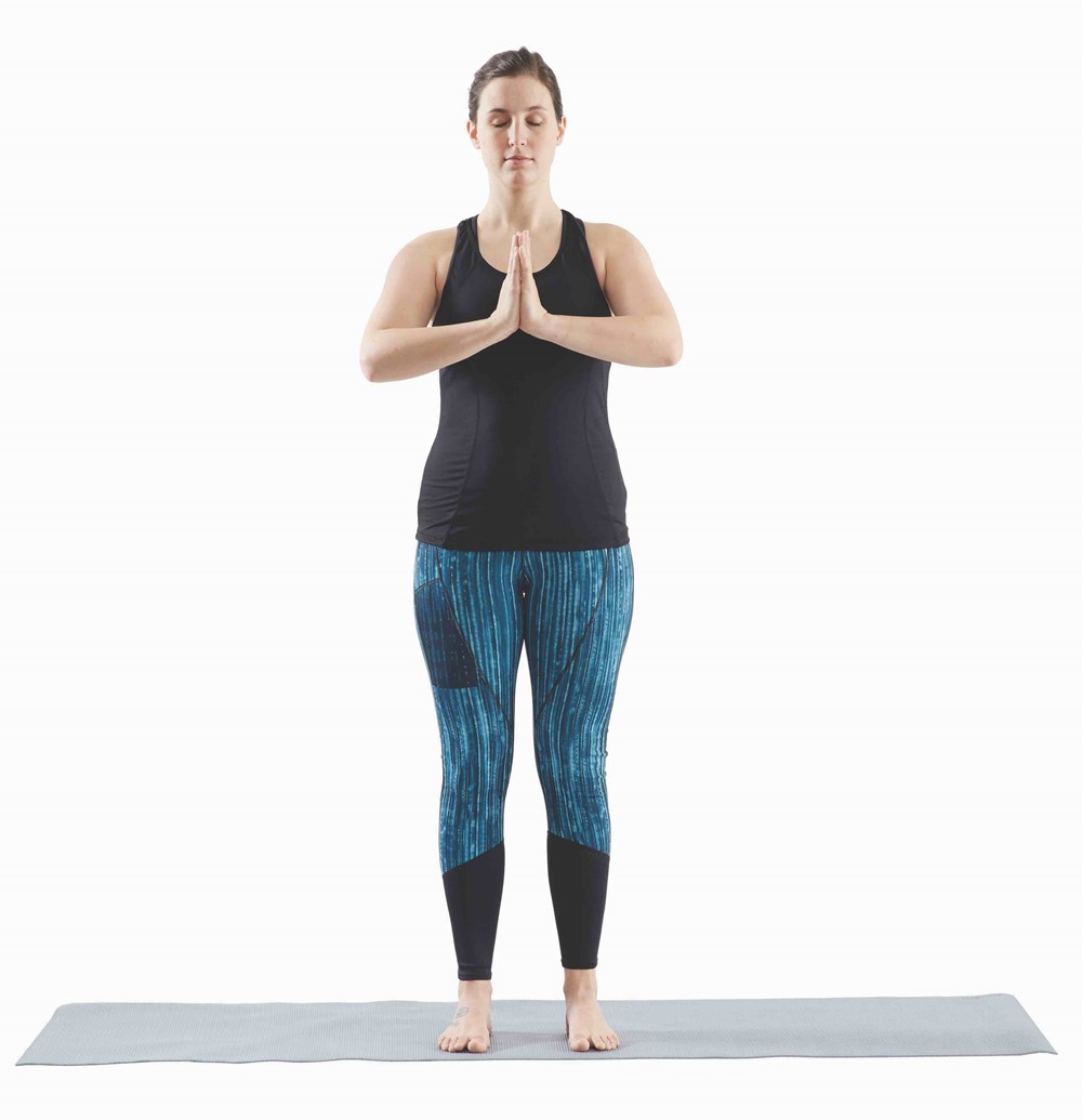 woman standing straight up with hands in prayer position