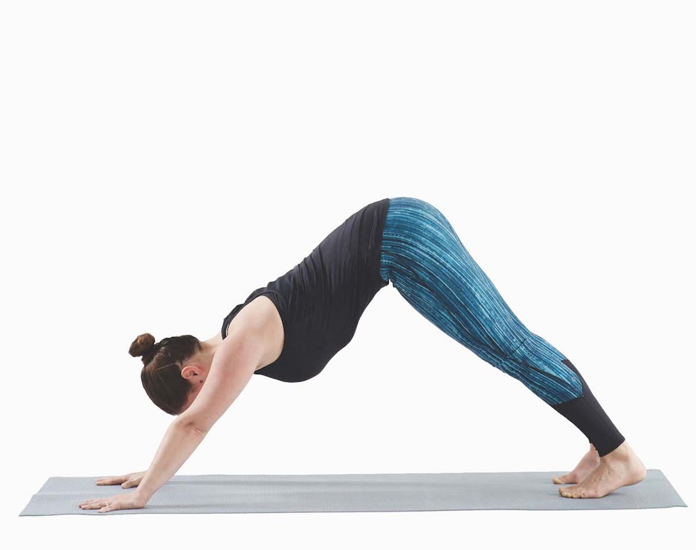 woman with her hands and feet on the mat in the position of an inverted v
