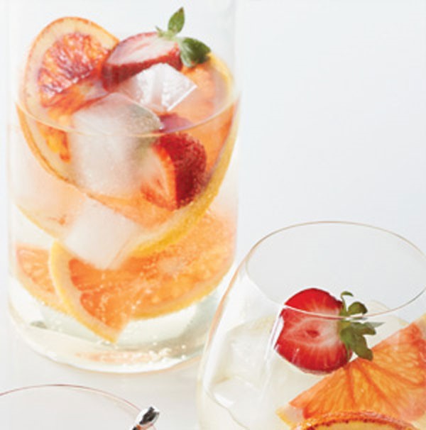 Glass of citrus-berry sangria filled with sliced grapefruit and strawberries