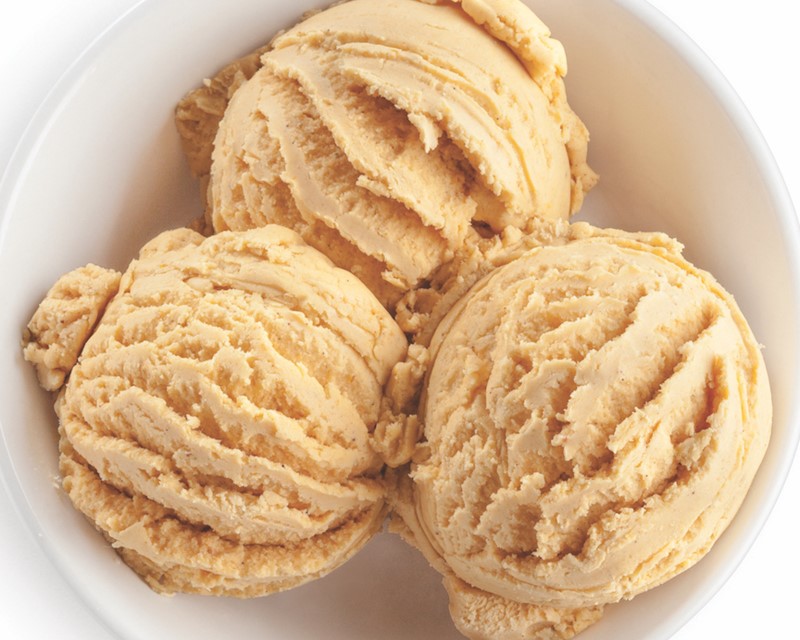 Three scoops of spiced pumpkin ice cream in a white bowl