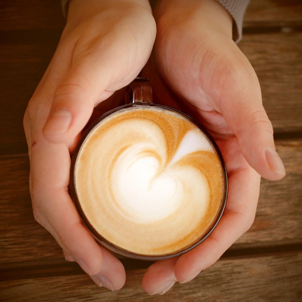 Cappuccino in Mug with Hands Holding 
