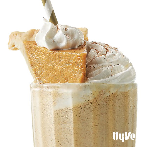 Pumpkin shake with mini pumpkin slice and whipped cream in glass