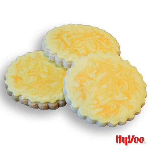 Three cut-out cookies with yellow-marbled royal icing 