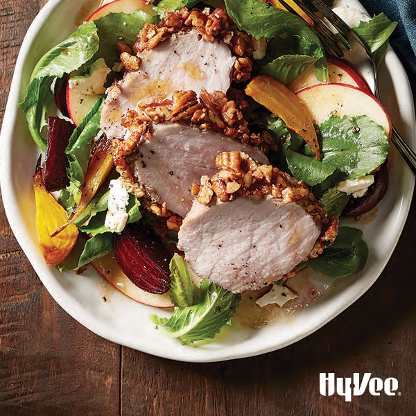 Pecan crusted pork loin on top of salad with apples and dressing
