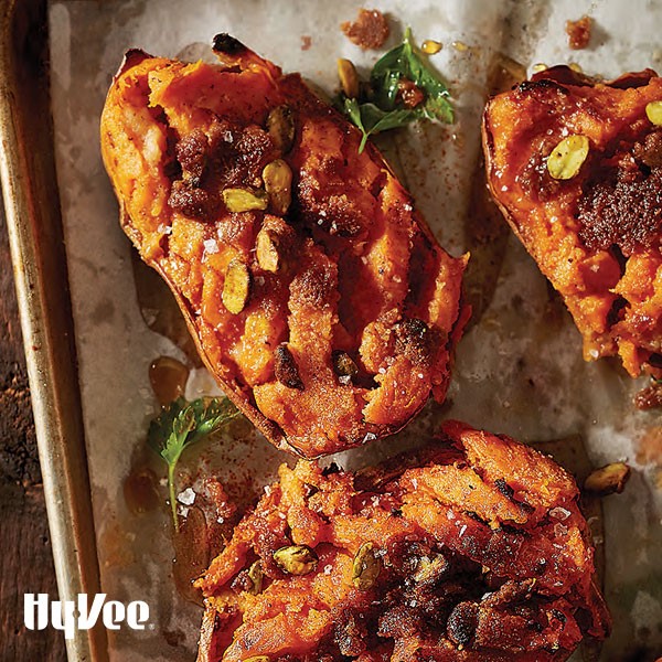 Sweet potatoes on baking sheet with pistachios and dried fruit