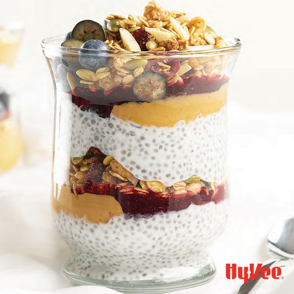 Chia pudding in jar with peanut butter and jelly swirls, blueberries and granola