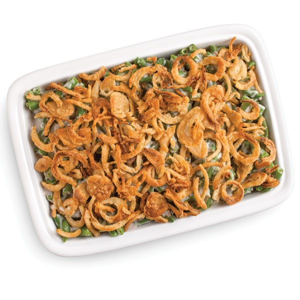 White casserole dish holding white sauced green beans and garnished with crunchy onions