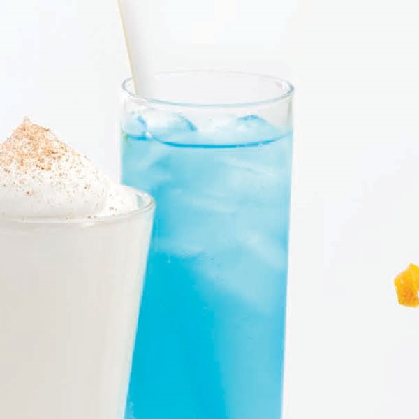 Tall slender glass filled with ice cubes, Blue-Hawaii drink and a white straw