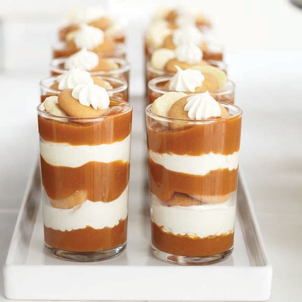 Pumpkin pudding parfaits served in juice glasses and garnished with whipped topping, vanilla wafers and sliced bananas