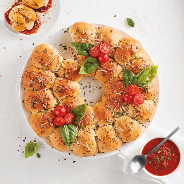 Platter of rolls topped with mozzarella, tomatoes, basil and served with tomato basil dipping sauce
