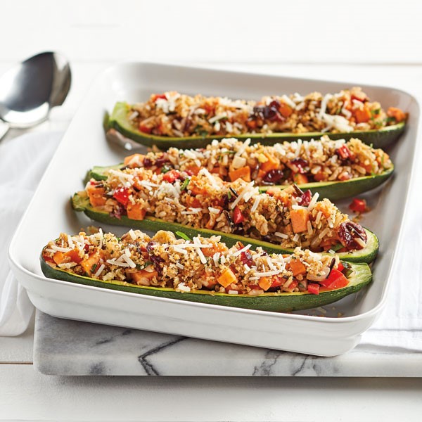 Tray of zucchini boats filled with sweet potato, red bell pepper, onion, cranberries, rice, breadcrumbs and parmesan cheese