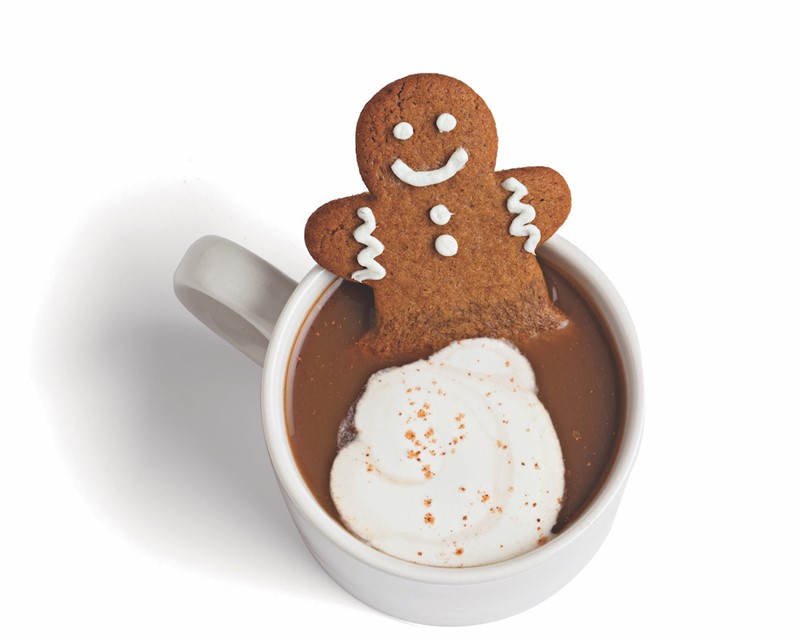 gingerbread man cookie in a mug full of coffee and milk