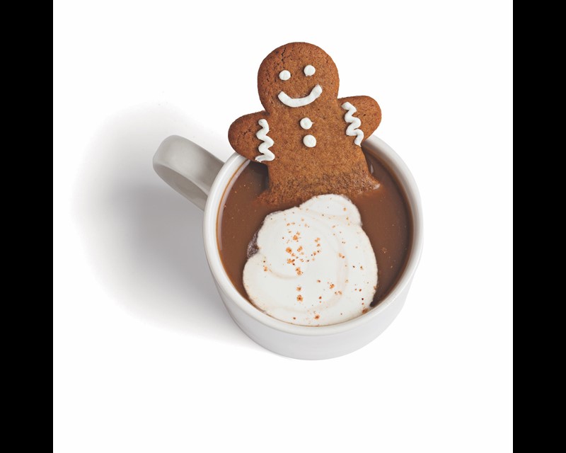 gingerbread man cookie in a mug full of coffee and milk