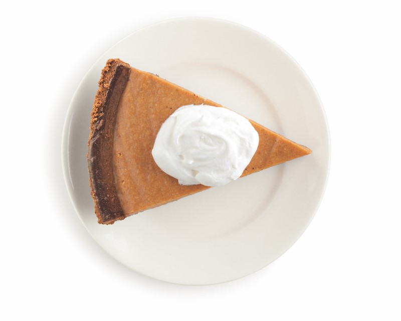 piece of pumpkin pie on a plate with whipped cream on top