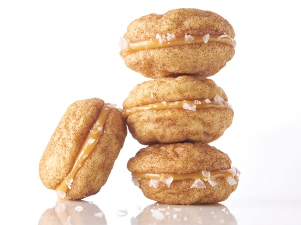Snickerdoodle cookie sandwiches filled with caramel and dipped in coarse salt