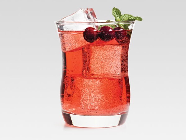 Glass of Crown cranberry cocktail, garnished with cranberries and mint sprigs