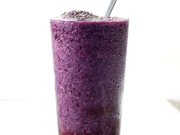 Glass of blueberry-orange power smoothie with a spoon